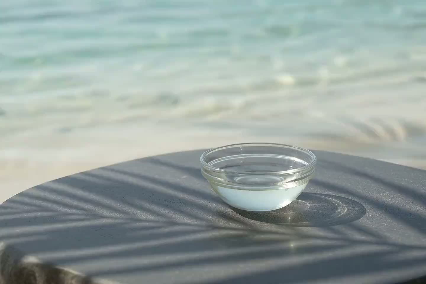 Wellness Brand concept image showing a glass bowl on a stone surface beside the lagoon